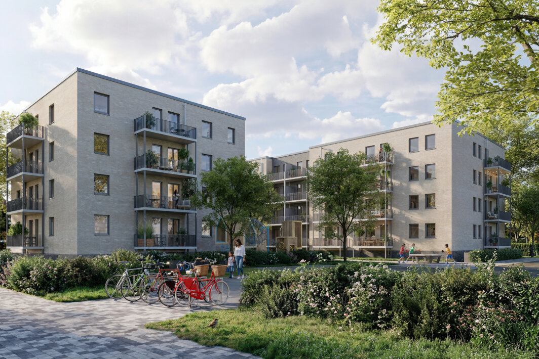 Mehrgeschossige moderne Wohnanlage mit Balkonen, begrüntem Innenhof, Spielplatz, Fahrrädern und mehreren Menschen auf Wegen und im Außenbereich.