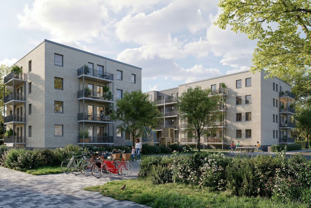 Mehrgeschossige moderne Wohnanlage mit Balkonen, begrüntem Innenhof, Spielplatz, Fahrrädern und mehreren Menschen auf Wegen und im Außenbereich.