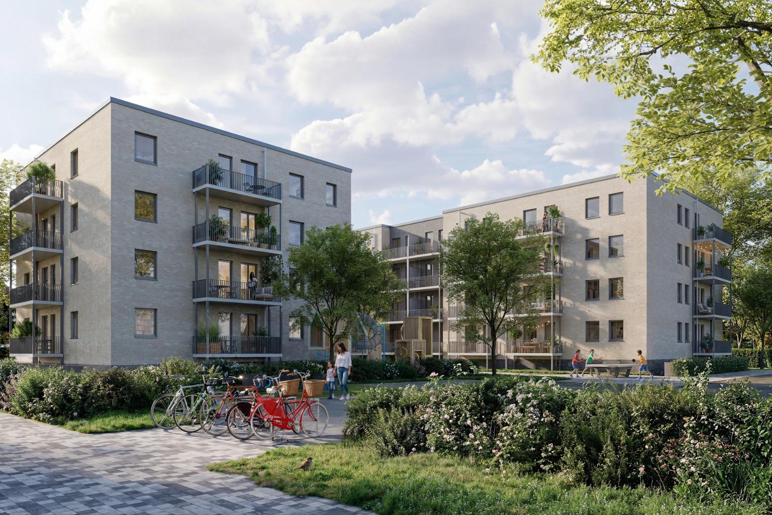Mehrgeschossige moderne Wohnanlage mit Balkonen, begrüntem Innenhof, Spielplatz, Fahrrädern und mehreren Menschen auf Wegen und im Außenbereich.